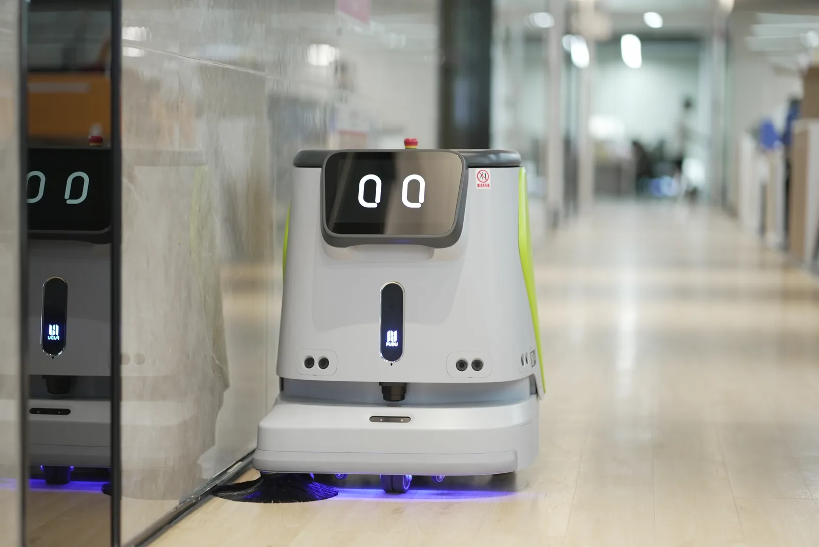 PUDU CC1 cleaning robot working a hard floor in an office building