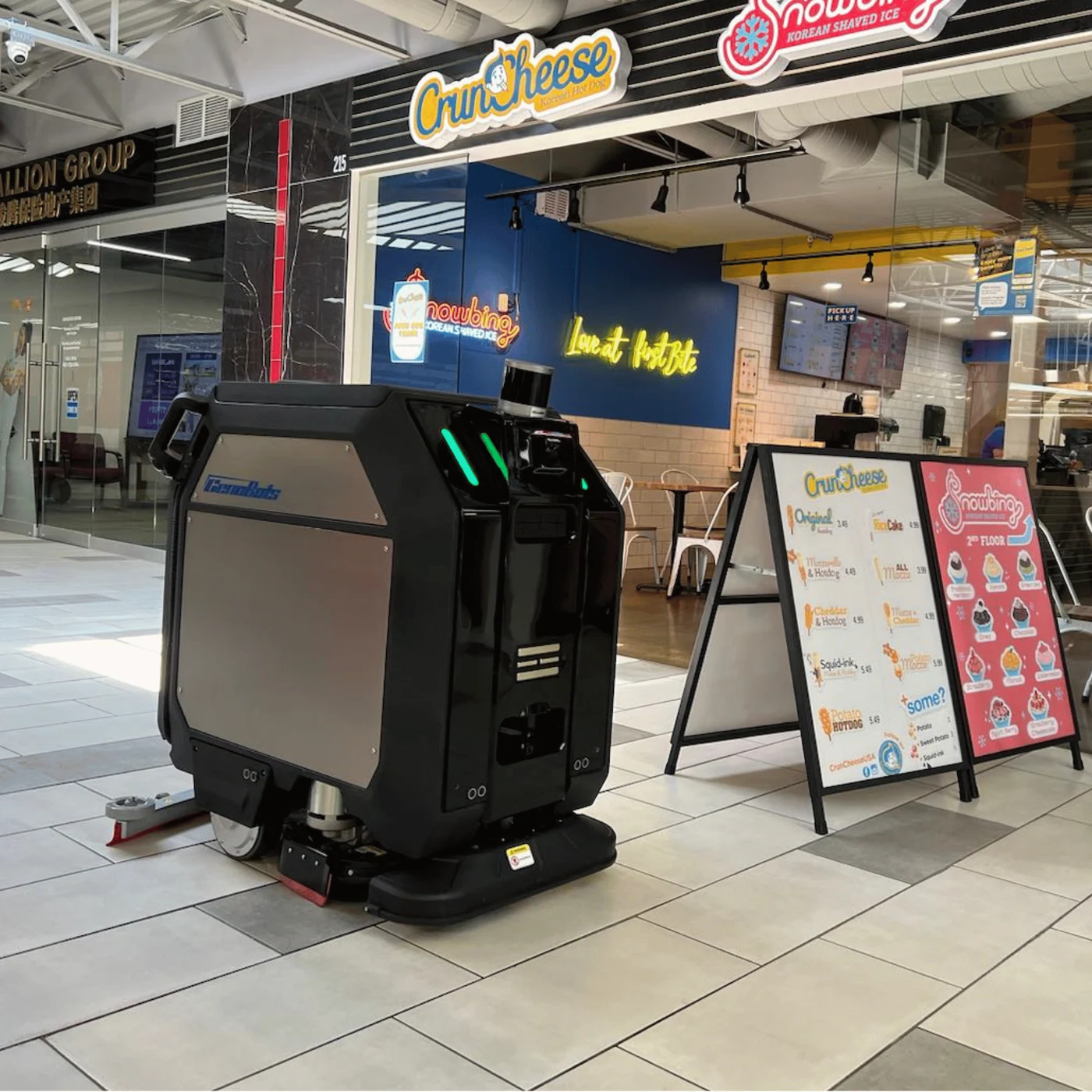 Autonomous floor scrubber working a shopping centre food court between tables